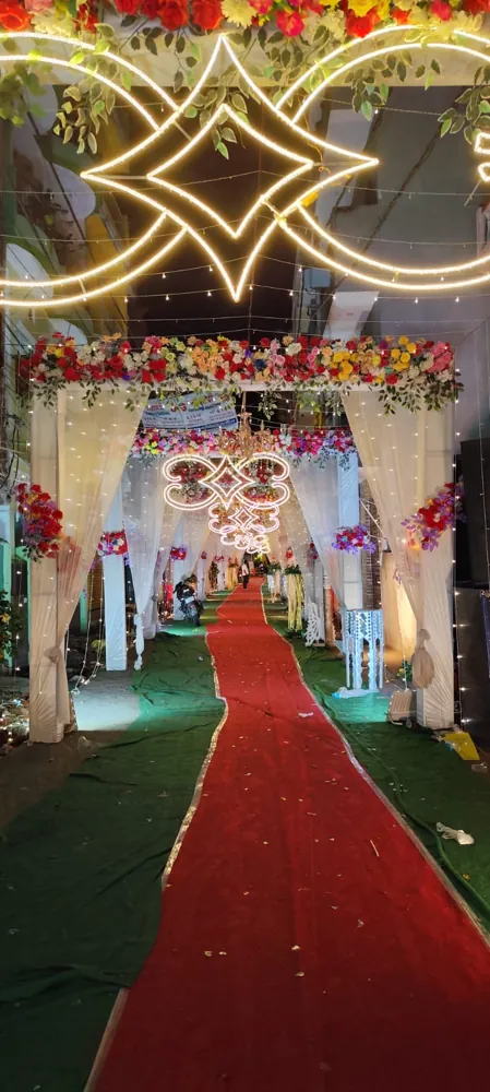 Wedding entry gate and pathway decoration with flowers, fairy lights and red carpet in Patna